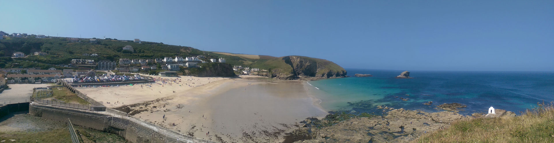 Panorama of Portreath Beach with blue skies and clear blue water